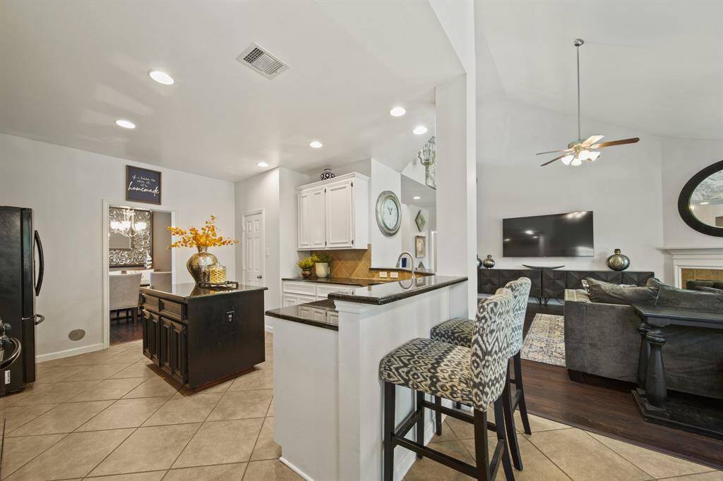 This open-concept kitchen features a raised breakfast bar overlooking the family room, perfect for casual dining or entertaining guests.