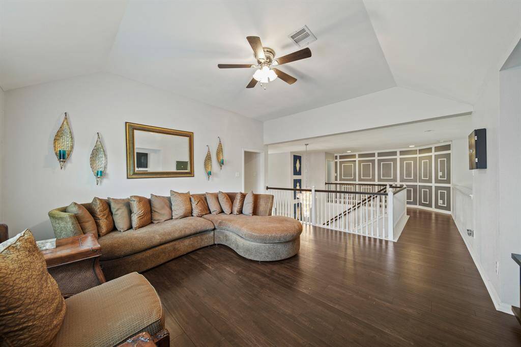 The game room provides ample seating space with room to spare for additional activities, complemented by a soaring ceiling and fresh, neutral tones.