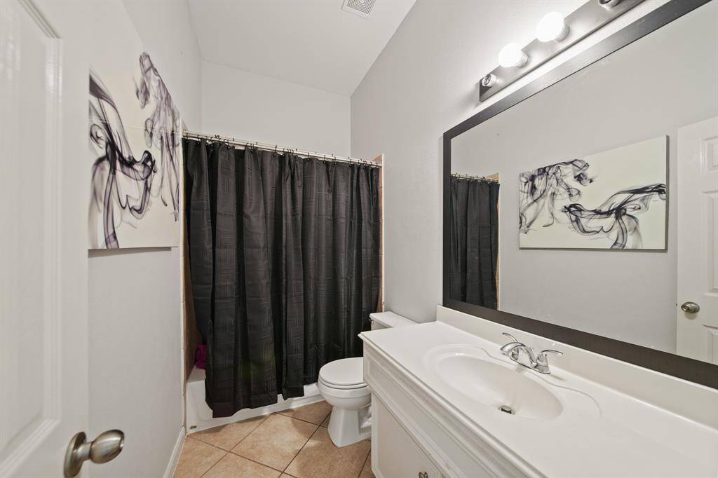 The connected bath offers tile flooring, an extended single sink vanity, designer lighting, and a convenient tub/shower combination.