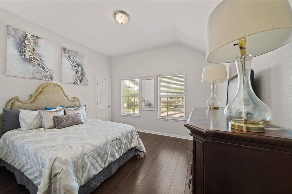 This is another generously sized bedroom featuring elevated ceilings, a generous walk-in closet, and bright windows overlooking the front yard.