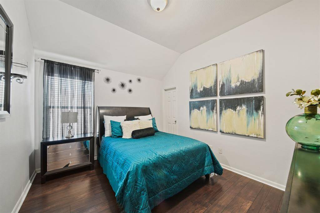Light and airy with vaulted ceilings and soft natural light, this bedroom offers a peaceful retreat and features a spacious walk-in closet.