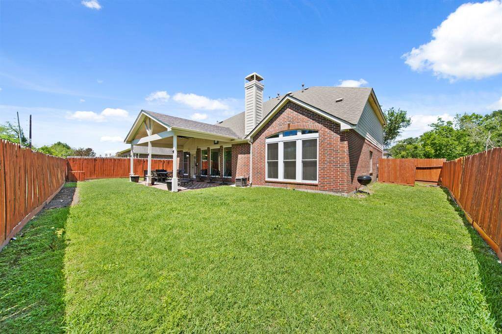 With a backdrop of lush trees and ample room to roam, this backyard is the perfect outdoor escape for relaxing or entertaining.