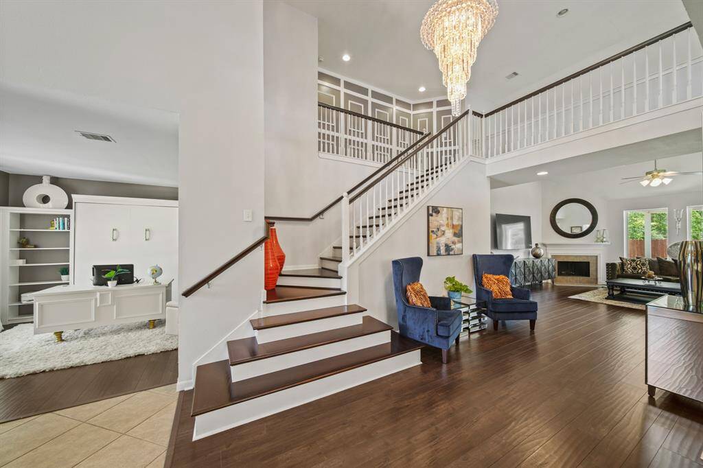 The foyer opens to a graceful staircase and introduces the home’s flowing layout, offering a warm welcome with gleaming floors, and views into the living room and office.