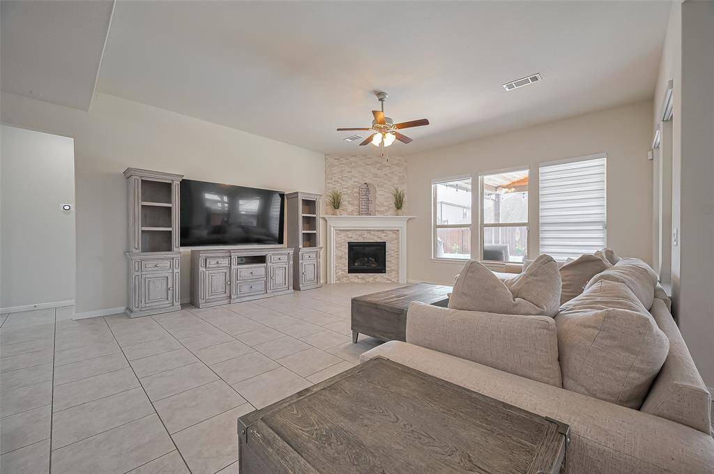 Living Room (TV view):Gather the family in this spacious living area, complete with a stone fireplace for chilly winter evenings. Long wall ready for any entertainment center you have and gret views of the patio and pool beyond.