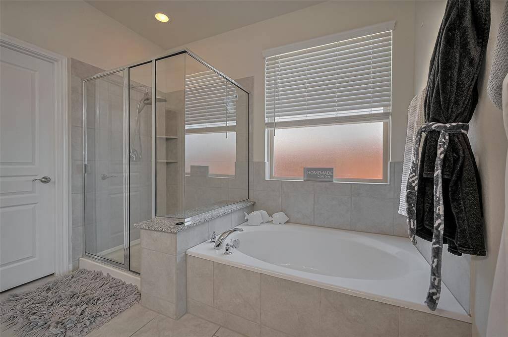 Another angle of the walk-in shower and soaking tub, highlighting the spa-like layout and natural light that fills the space.
