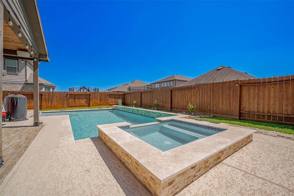 This wide-angle view showcases the impressive scale of the patio area, complete with multiple lounging zones, mounted TV, and ample seating space for guests. The perfect setup for game days, summer nights, and everything in between.