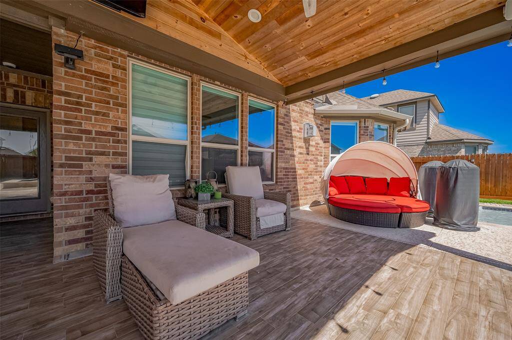 Kick back in this cozy lounge zone designed for peaceful mornings or evening wind-downs. The shaded area offers direct pool views and easy access to the main living space inside.