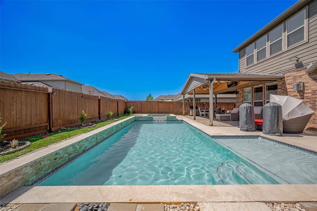 Dive into your personal paradise! This gorgeous pool features a built-in spa, modern tile accents, and waterfall feature—ideal for both relaxation and play. Surrounded by privacy fencing and minimal landscaping for low maintenance.