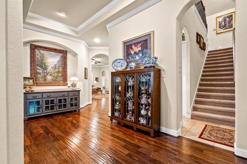 Beauty and elegance with an inviting entryway features elegance with art niches, arched doorways and trayed ceiling with crown molding.  To the right is easy access that leads upstairs, Kitchen and garage.