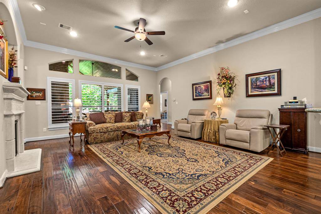 This spacious Living Room features elegant hardwood floors, a Gas Fireplace, and custom built in's. Large windows with Plantation Shutters that allow plenty of natural light, and allows you to see the gorgeous outdoor covered Patio that creates a warm and inviting atmosphere.