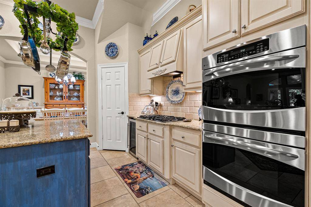 Gas Cooktop and Double Ovens are a few of the features and elegant cabinetry with granite countertops, The space is accented with hanging pot rack that can hold all your pots and pans, offering a cozy, traditional feel.
