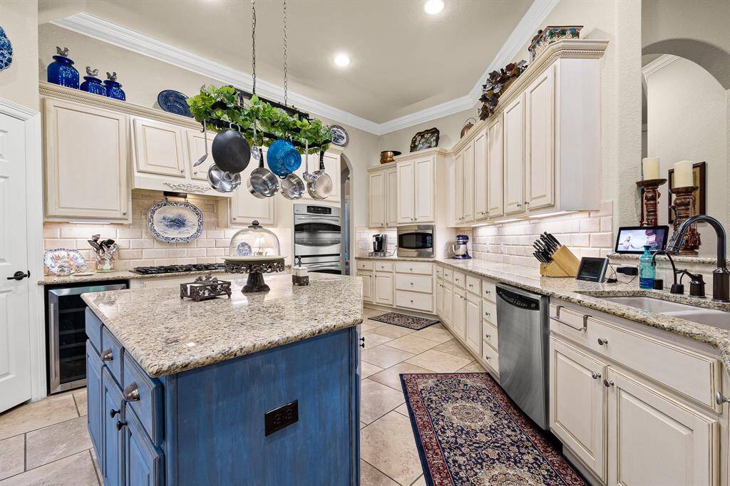 The Kitchen features elegant central island with pot and pan drawers and abundant cabinetry. Upgraded Stainless Steel Appliances, a Double Oven, and a hanging pot rack adding functionality. The cabinets have under lighting along with lighting above to display your collections.