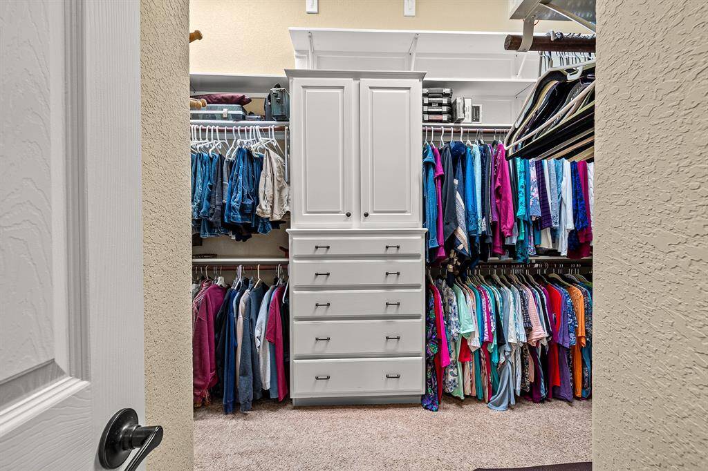 This luxurious spacious walk-in closet with loads of storage, featuring built-in shelves and drawers. It has 3 levels of hanging spaces, offering a well-organized and functional space for clothing and accessories.  Be sure and check it out!