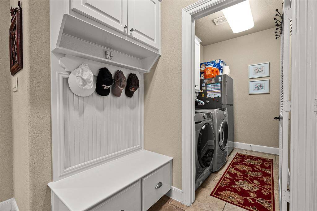 Well-organized Utility Room is in a great location. It has cabinets with room enough for washer-dryer-refrigerator, The Mud Room has built-in storage and hooks for hats or coats, offering convenient functionality and efficient use of space.  The 2 Car Garage is across from the Utility Room.