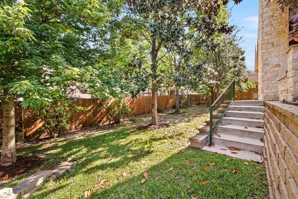 Relax and step down unto your backyard that offers a peaceful outdoor space for relaxation and entertainment.  Your welcoming backyard offers multiple ways to  enter the backyard.  It offers a side yard that will give additionals space to entertain. The yard features a beautiful Magnolia and other trees, providing a peaceful and shaded outdoor space.