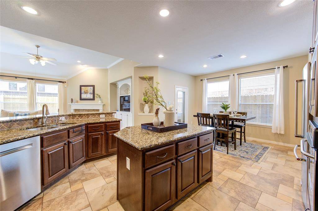 The heart of the home, this island kitchen offers a functional and stylish layout with a direct view into the living room—perfect for entertaining or keeping an eye on the family. Features include rich cabinetry, ample counter space, and a central island that provides additional seating and prep space, all within an open-concept design that promotes easy flow and connection.