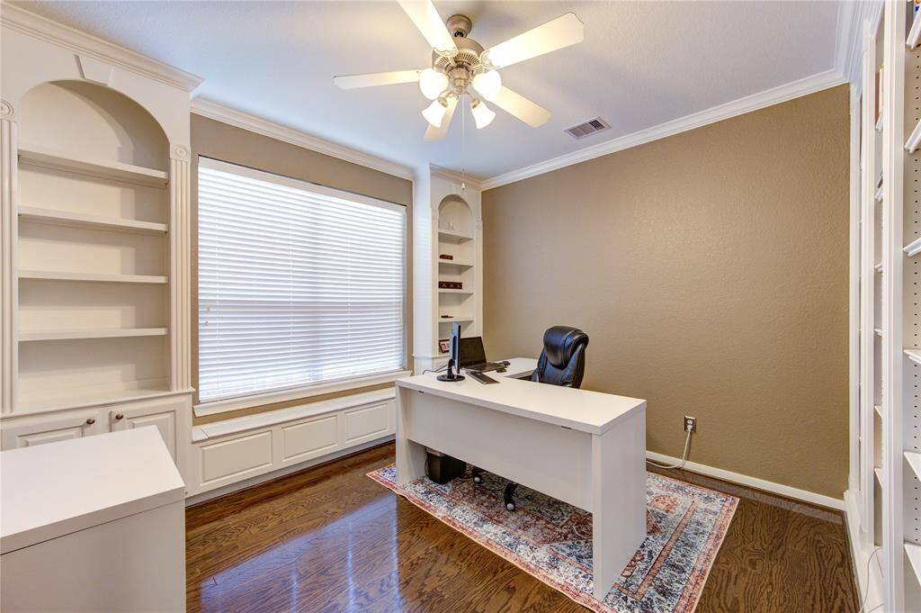 This private study offers a serene and productive environment, featuring elegant wood floors, custom built-in shelves for storage or display, and a large picture window that floods the room with natural light while offering peaceful views of the front yard. The thoughtful design makes it perfect for a home office, library, or quiet reading room.