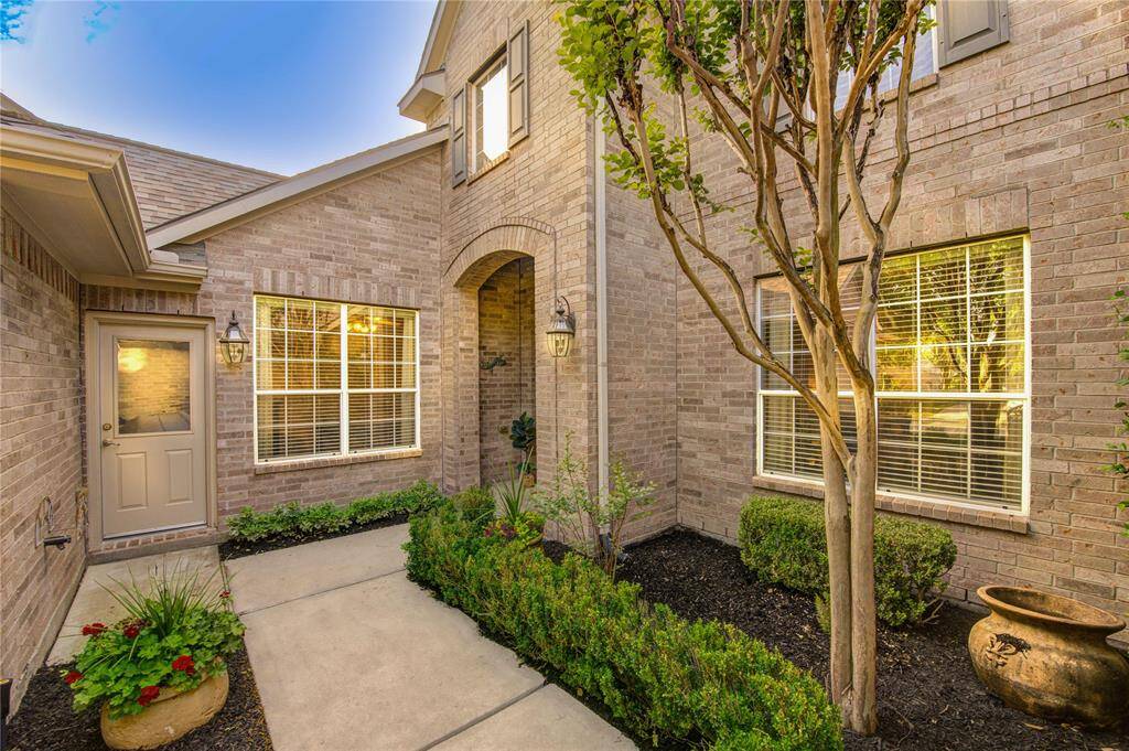 Charming curb appeal welcomes you with a courtyard-style front entry, freshly mulched flower beds, and manicured landscaping that creates a warm and inviting first impression.