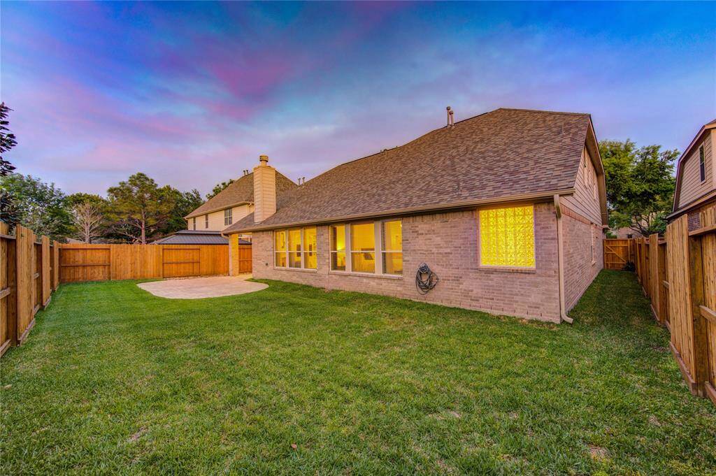 The fully fenced yard provides room for pets, play, or a future pool. The roof’s recent replacement extends to the back elevation, providing durability and protection across the entire home.