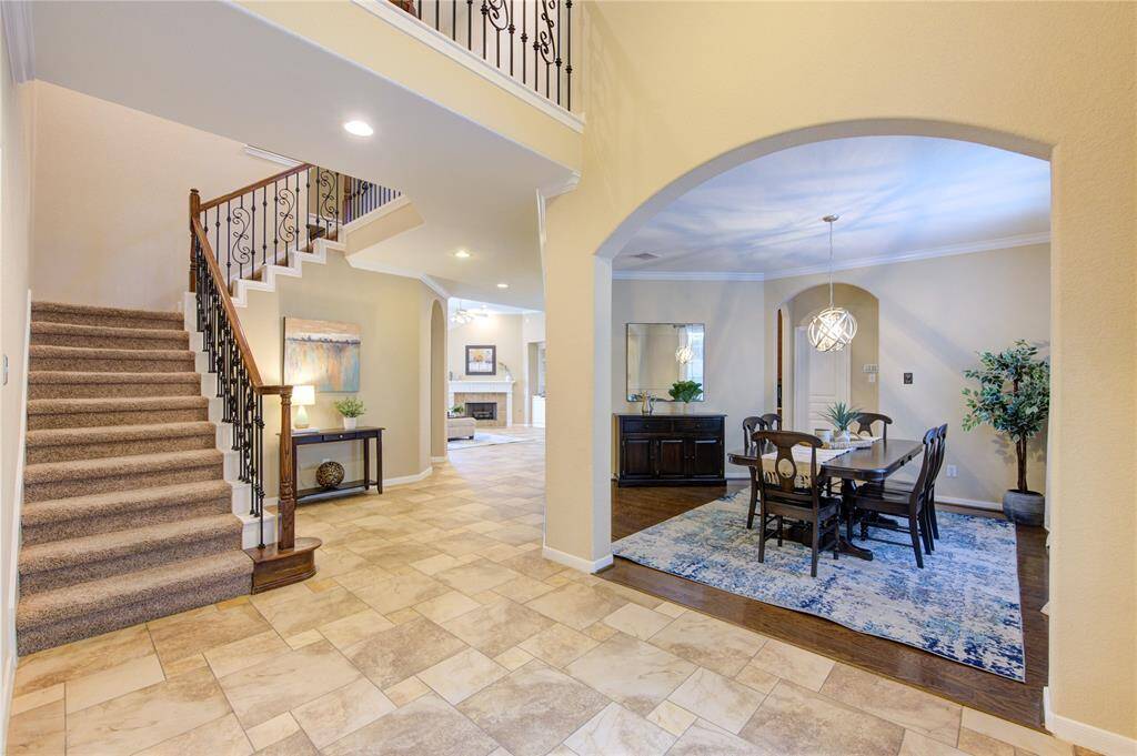 Step inside to a soaring two-story foyer that fills with natural light. Neutral tile floors, graceful archways, and a wide hallway create an elegant and open introduction to the home’s thoughtful floorplan.