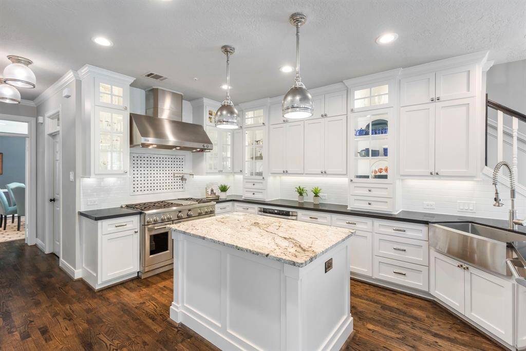 This beautifully updated kitchen shines with in-cabinet and under-cabinet lighting, showcasing sleek finishes and a smart, open layout that's as functional as it is stylish