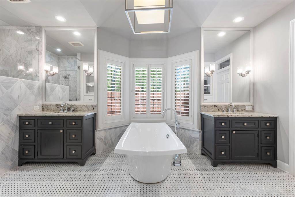Unwind in the primary bath, featuring a luxurious soaking tub and a tranquil, spa-like ambiance.