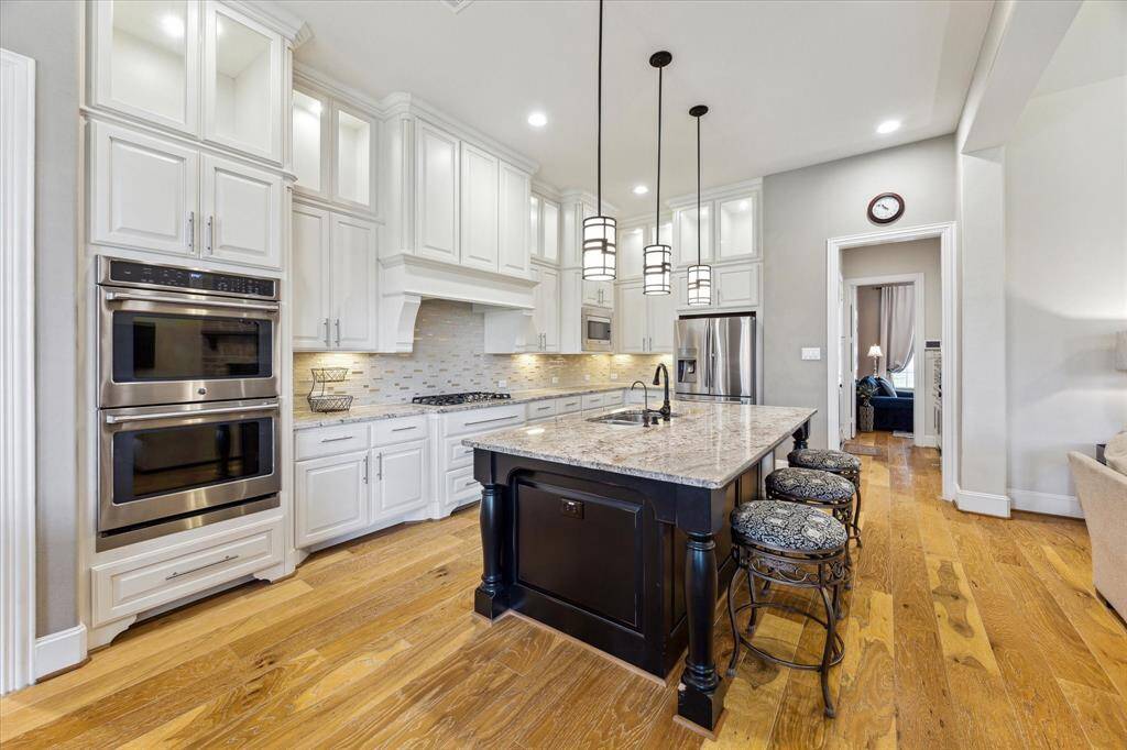 Chef's Kitchen with large island, double ovens and 5-burner gas cooktop.