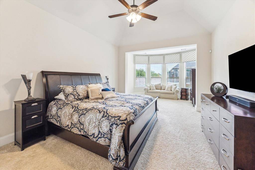 Spacious primary suite with a wall of windows overlooking the backyard.