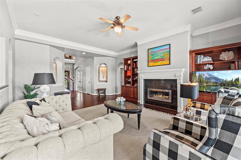 The inviting center fireplace becomes a focal point that anchors the room and invites people to gather and linger, making it a cherished feature of the living area.