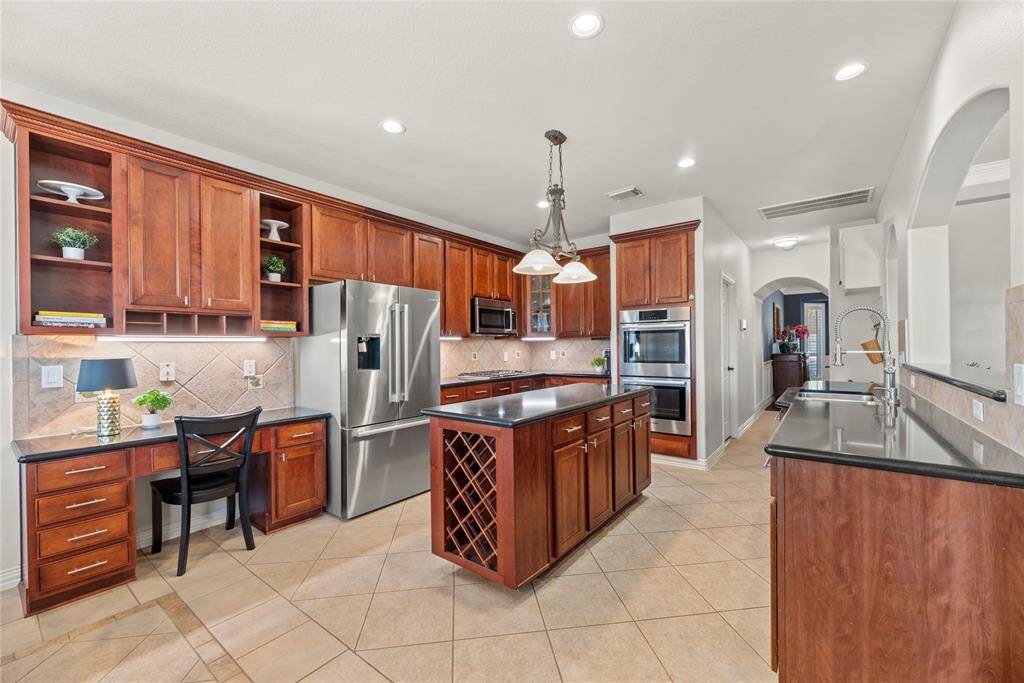 Your chef-inspired kitchen is ready to impress! This beautifully designed space offers gleaming granite countertops, a coordinating stone backsplash, and sleek stainless steel appliances. The rich cabinetry, enhanced with updated hardware, is perfectly complemented by under-cabinet lighting and recessed lighting, creating a bright and inviting ambiance. At the heart of it all, a sprawling center island.