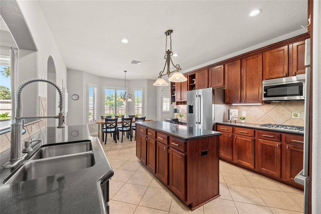 Granite countertops paired with a coordinating stone backsplash not only provide a durable and elegant surface for food preparation but also add a touch of luxury and sophistication to the kitchen.