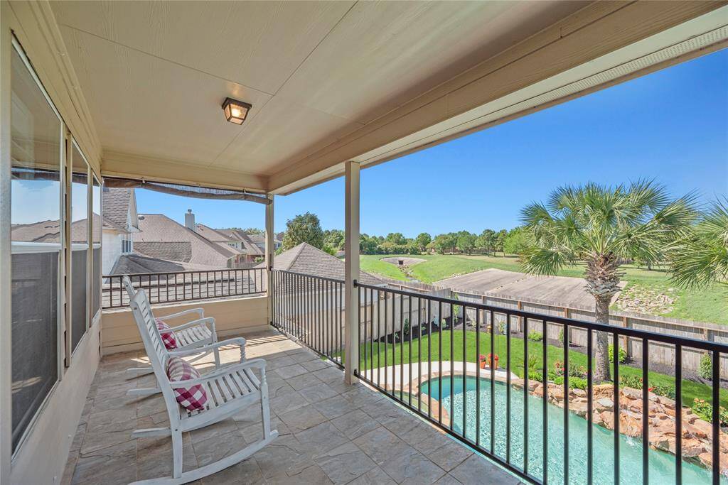 Step out onto the private balcony veranda just off the second-floor living area, offering a tranquil perch overlooking the stunning pool and lush backyard—an ideal spot to unwind, enjoy your morning coffee, or take in the serene views.