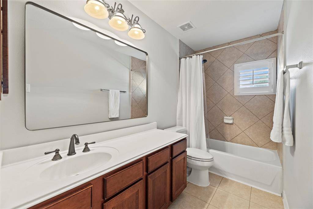 This secondary bath features a spacious vanity, making busy mornings a breeze for the whole family.