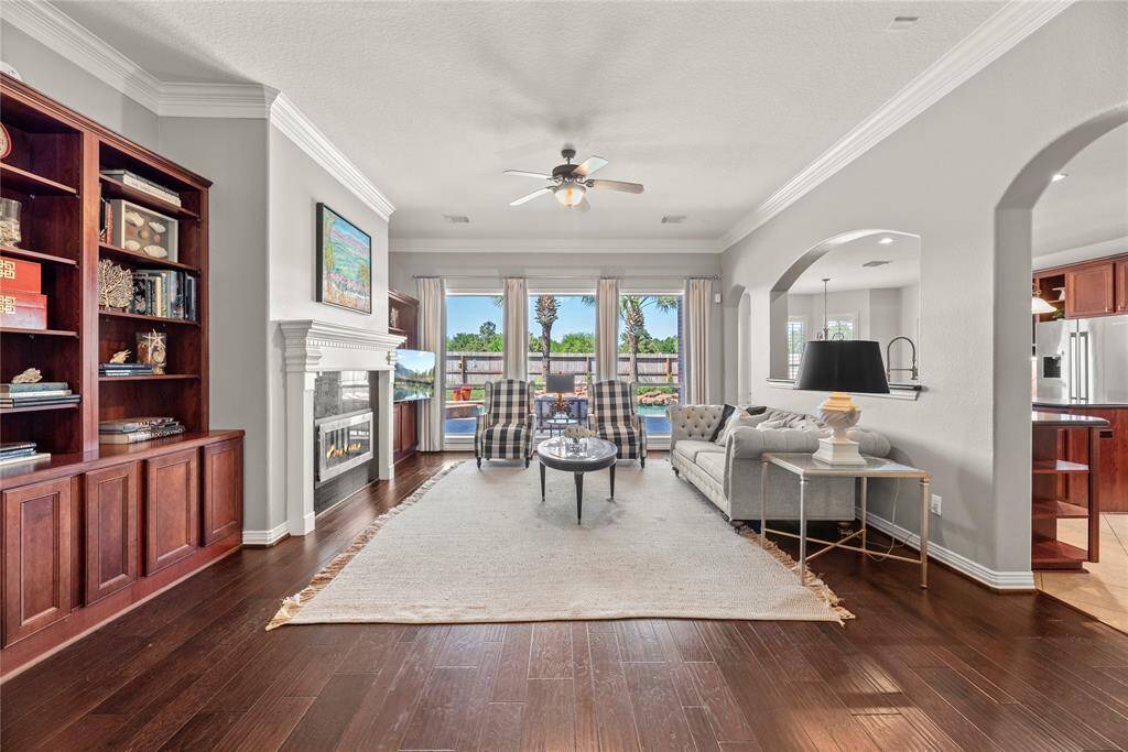 Step into the inviting living area—a warm and welcoming space perfect for relaxing, hosting, or simply enjoying time with loved ones. This sun-drenched room features a striking center fireplace as its focal point, with picturesque views of the backyard oasis adding to the peaceful ambiance and charm.