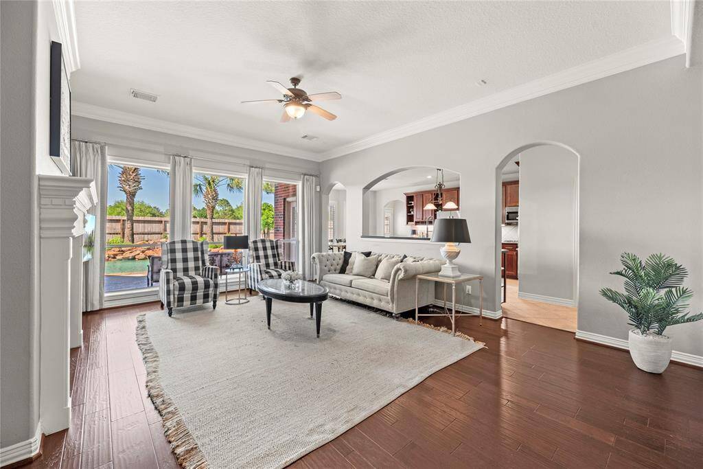 The living area boasts soaring ceilings, elegant crown molding, and a seamless open flow to the kitchen, creating a bright, airy atmosphere that’s perfect for both everyday living and entertaining.
