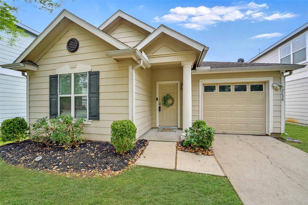 CHARMING COTTAGE STYLE HOME WITH ATTACHED GARAGE, DECORATIVE SHUTTERS AND COVERED PORCH.