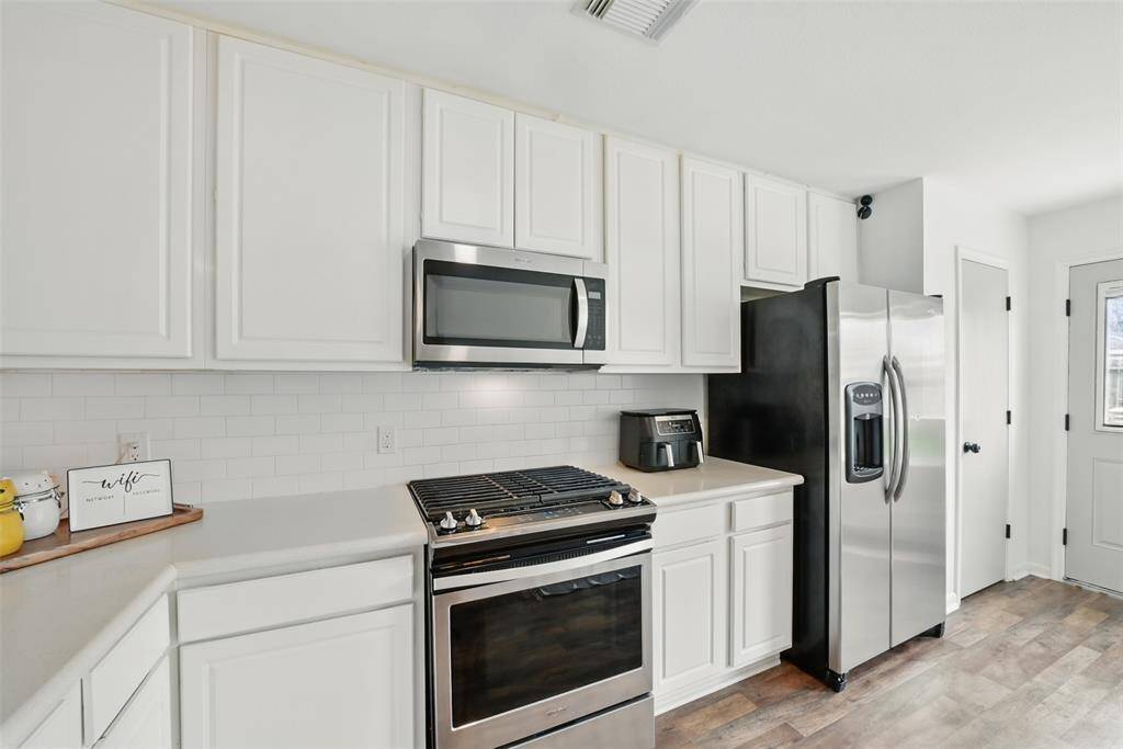 A CLOSE-UP OF THE MODERN STAINLESS STEEL APPLIANCES.