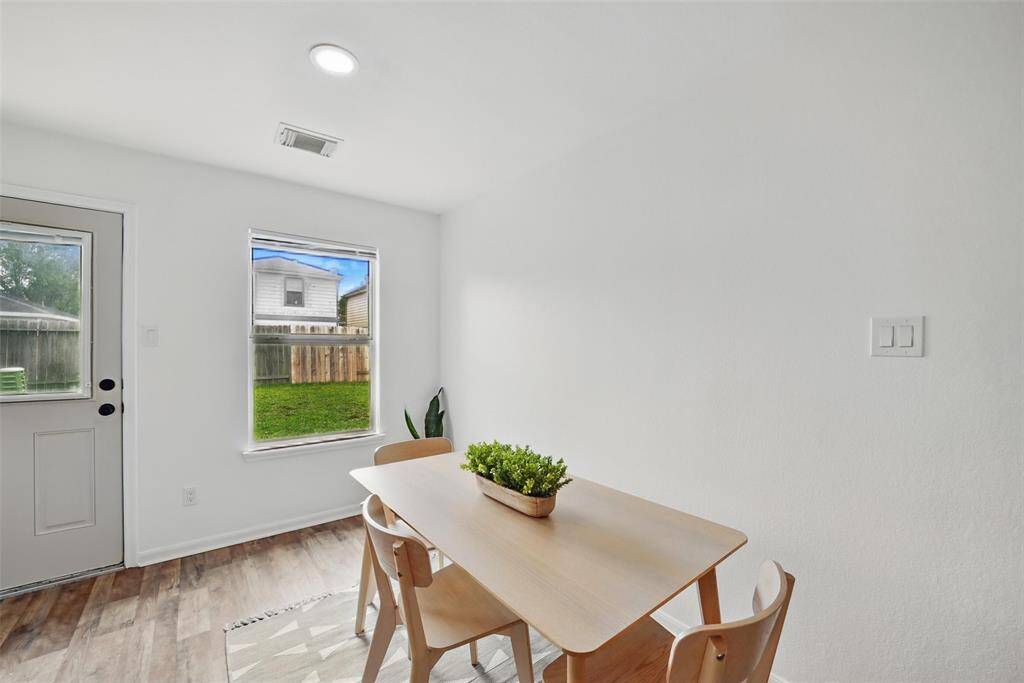 THE DINING AREA IS BRIGHT AND CHEERFUL WITH VIEWS OF THE LUSH BACKYARD.