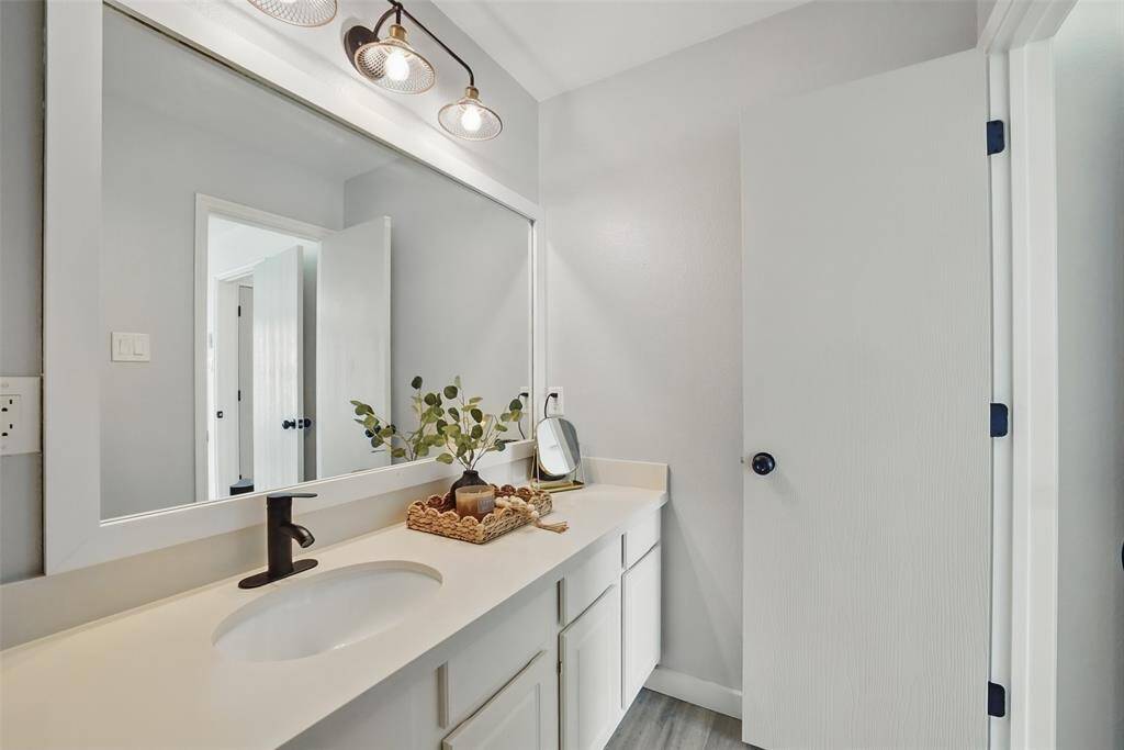 MODERNTHE EN-SUITE BATHROOM HAS LARGE FRAMED MIRROR AND STYLISH LIGHTING.