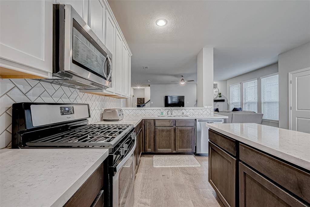 The beautiful backsplash, recessed lighting, and sleek finishes give this kitchen a polished, modern look.