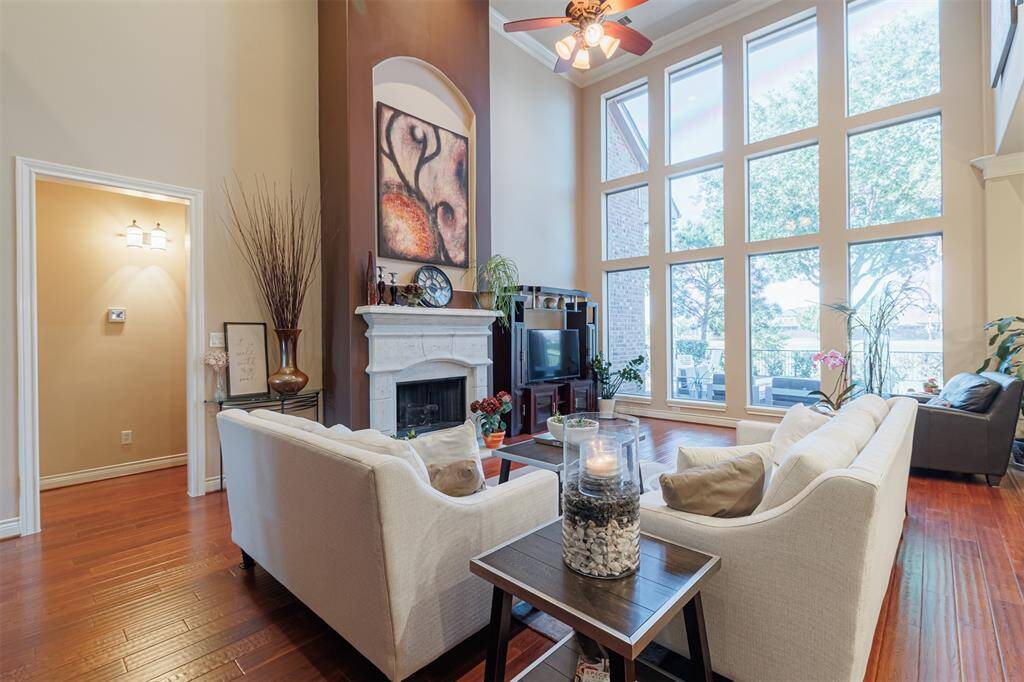 The spacious family room features wood flooring, soaring ceilings, gaslog fireplace, and floor to ceiling lake-facing windows.