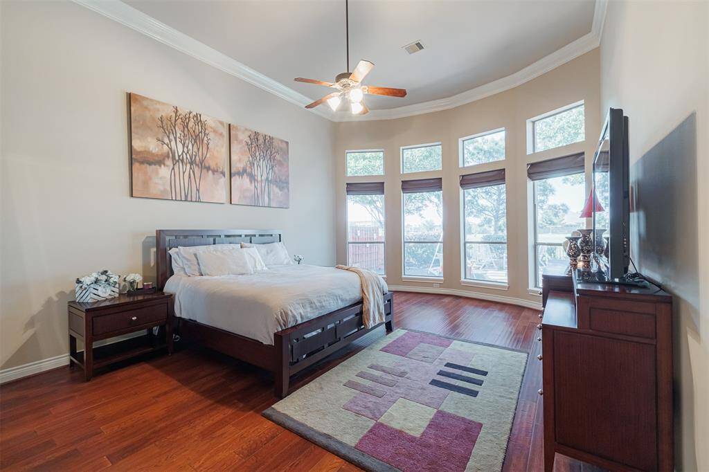The primary suite offers lake views, high ceilings, wood flooring and crown molding.