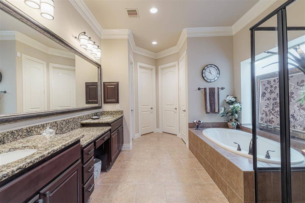 Spa-like primary bath with granite counters, double sinks, vanity and 2 walk-in closets.