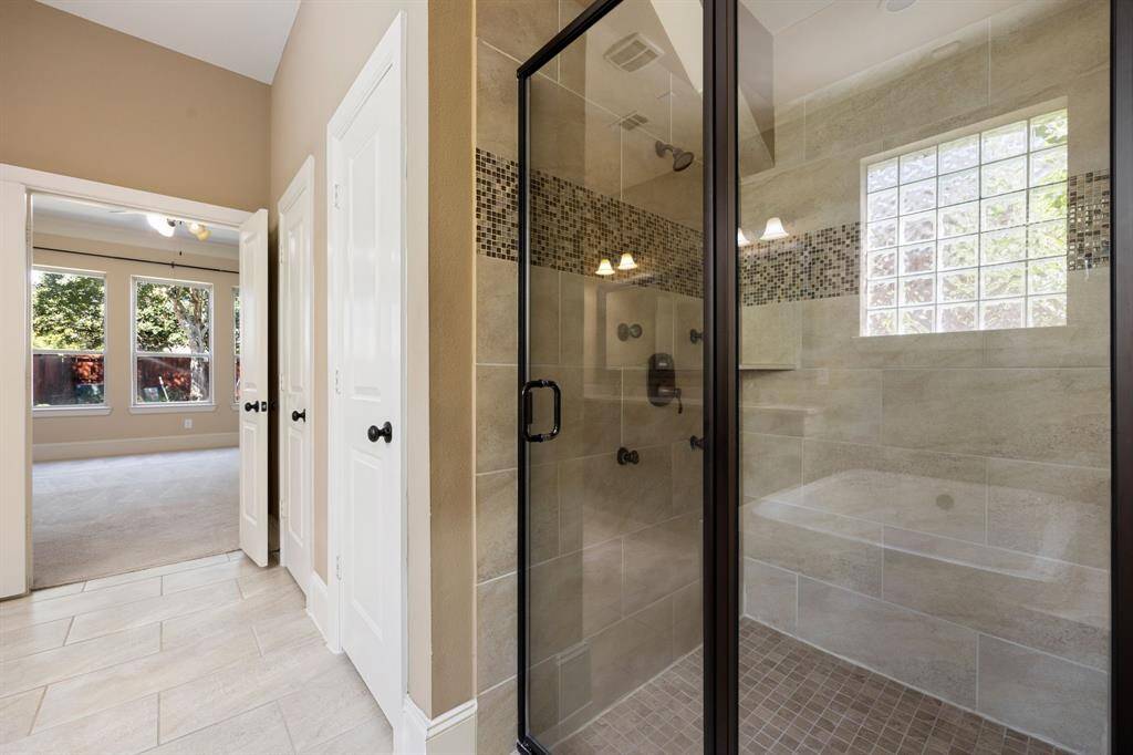 This additional view of the primary bath showcases a spa like walk-in shower with tile surround, perfect for soaking after a long day.