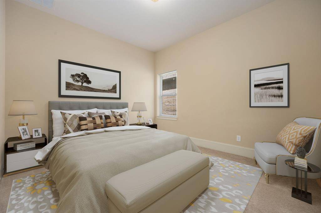 Secondary bedroom features plush carpet, neutral paint, dark stained ceiling fan with lighting and a large window with privacy blinds.