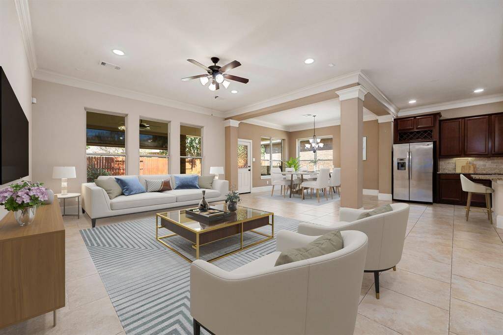 This inviting open-concept living area boasts abundant natural light, highlighted by large windows that offer a view of the backyard. The spacious layout flows seamlessly from the family room to the dining and kitchen, ideal for gatherings. Elegant crown molding, recessed lighting, and tile flooring add a touch of sophistication, while the rich, dark wood cabinetry in the kitchen provides warmth and ample storage. Enjoy the convenience of a well-designed space that combines comfort and style.