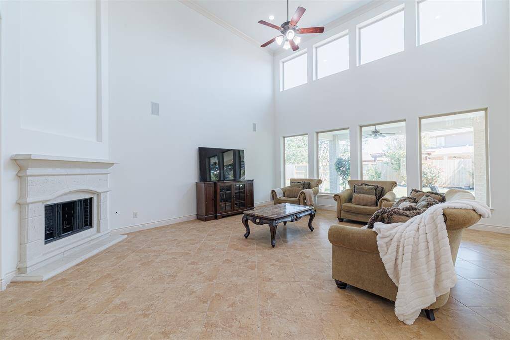 Spacious family room with soaring ceilings, gas fireplace & wall of windows overlooking the backyard.