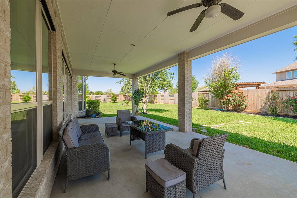 Oversized covered patio with 2 ceiling fans.