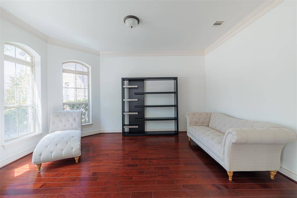 Formal living area with wood flooring and crown molding could also be used as a study.