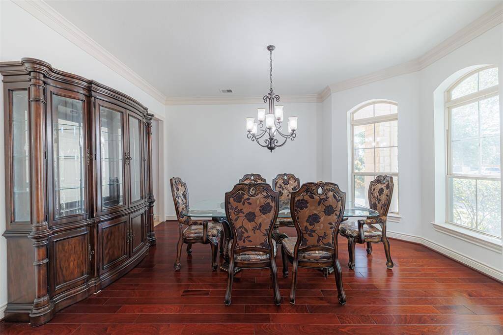 Formal dining room with wood flooring and crown molding.